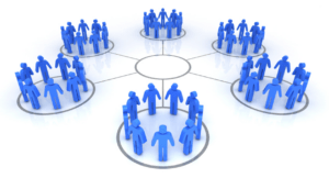 A diverse group of individuals stands together, forming a circle, engaged in conversation and interaction.